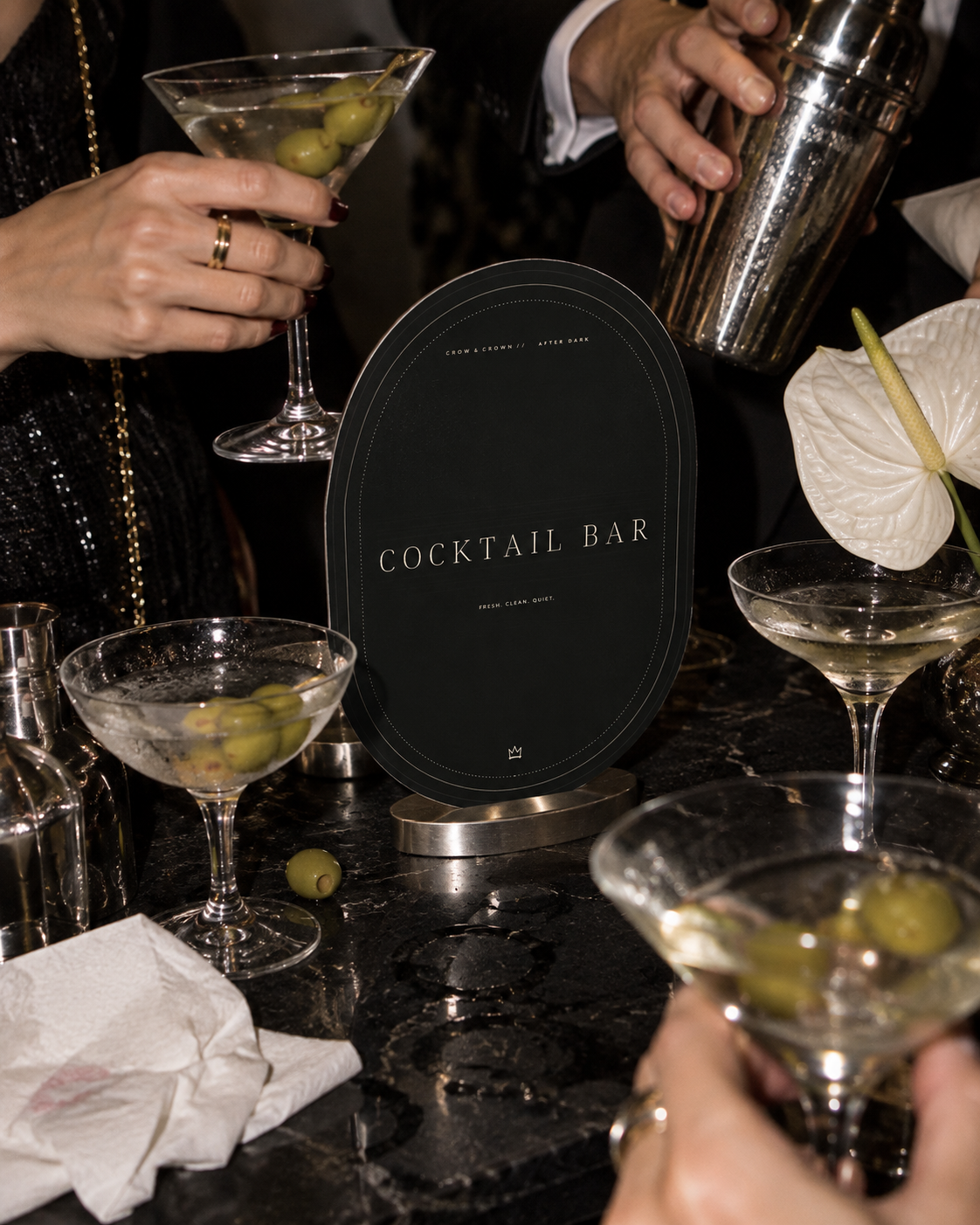 Cocktail Bar arched printable sign behind a tray of martini glasses