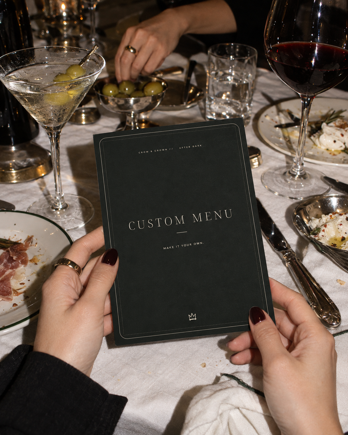 Custom Menu printable party card held above a dinner table with silver flatware