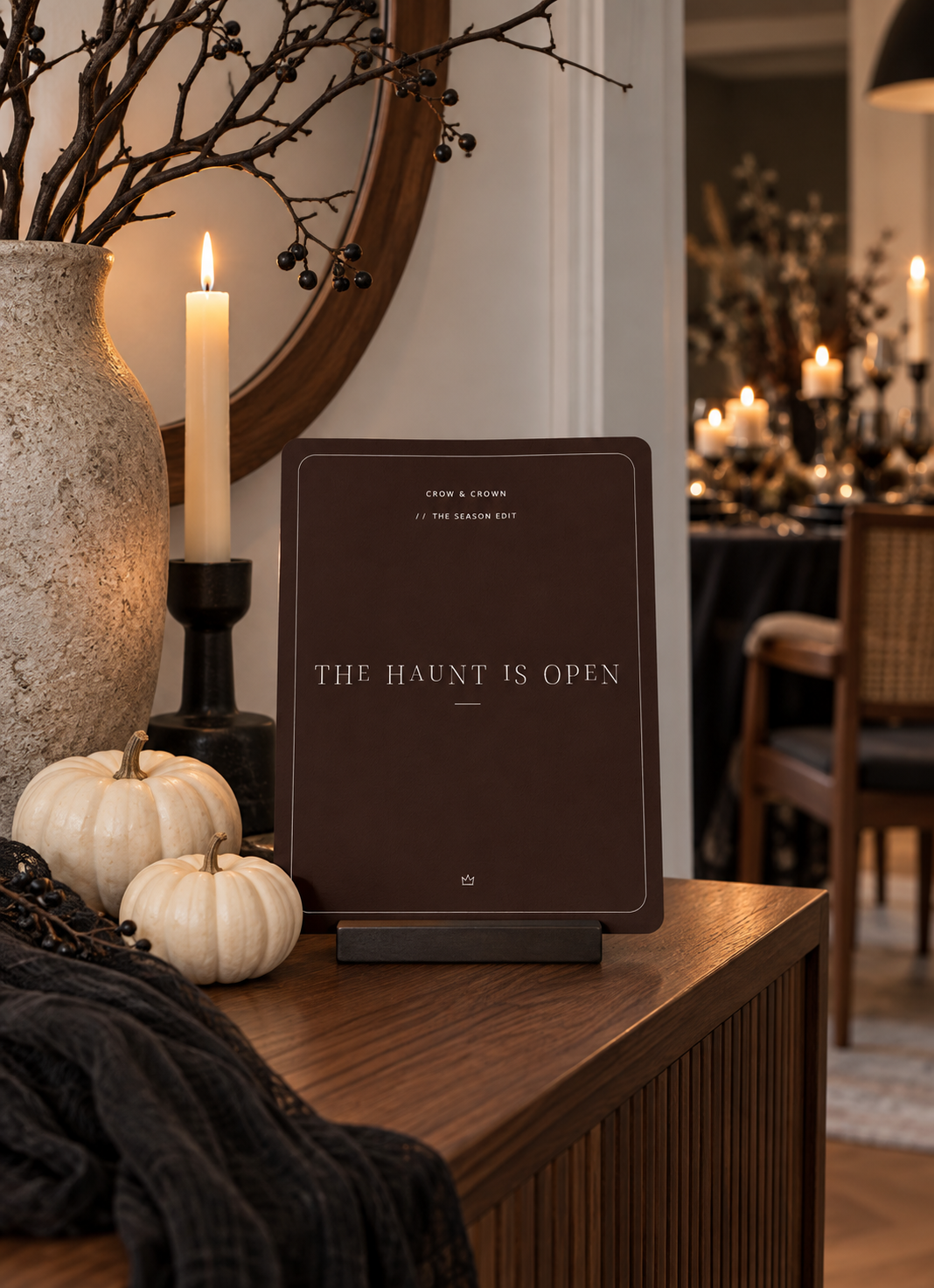 The Haunt Is Open Halloween printable on a console beneath a round mirror