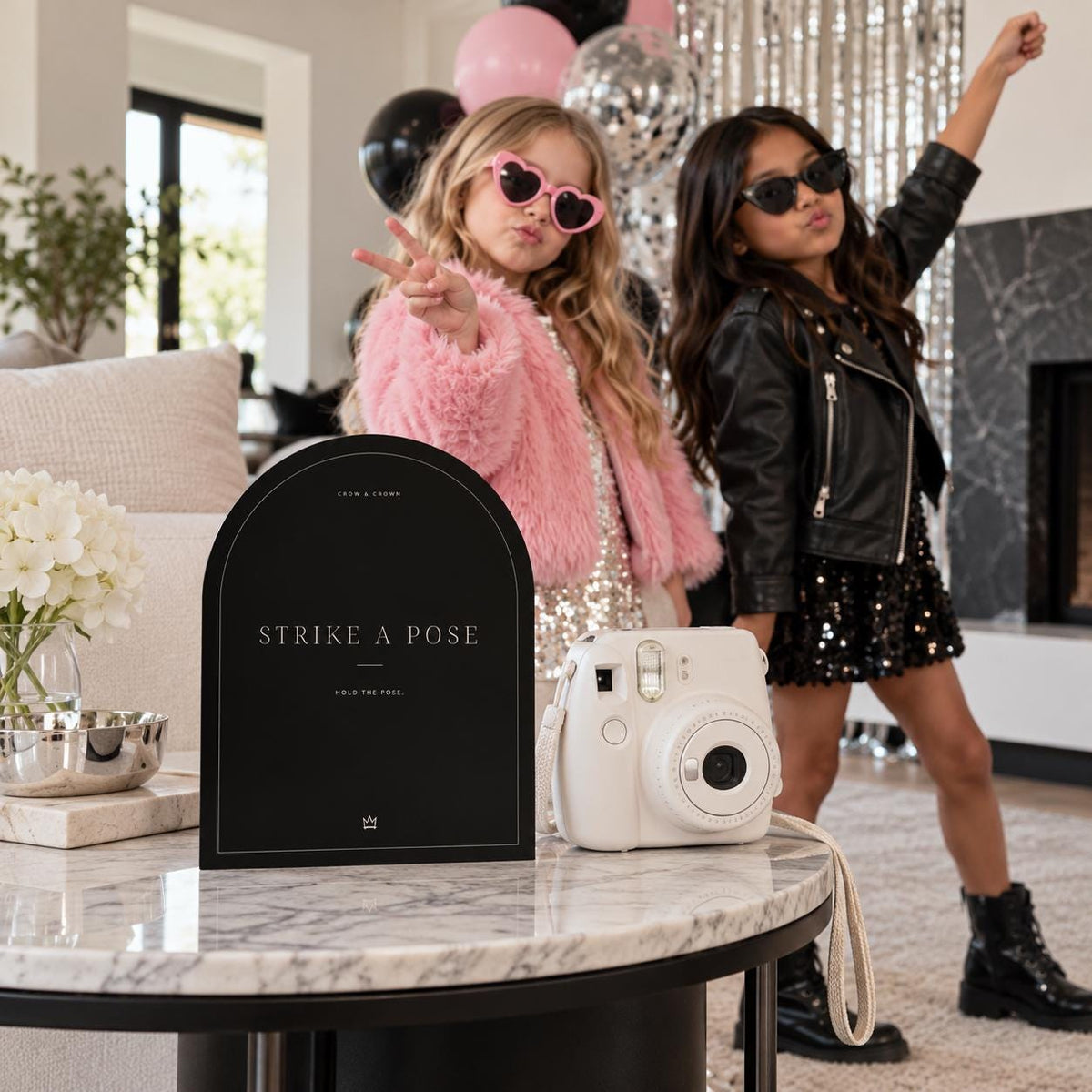 Strike a Pose fashion birthday printable beside an instant camera and children in party outfits