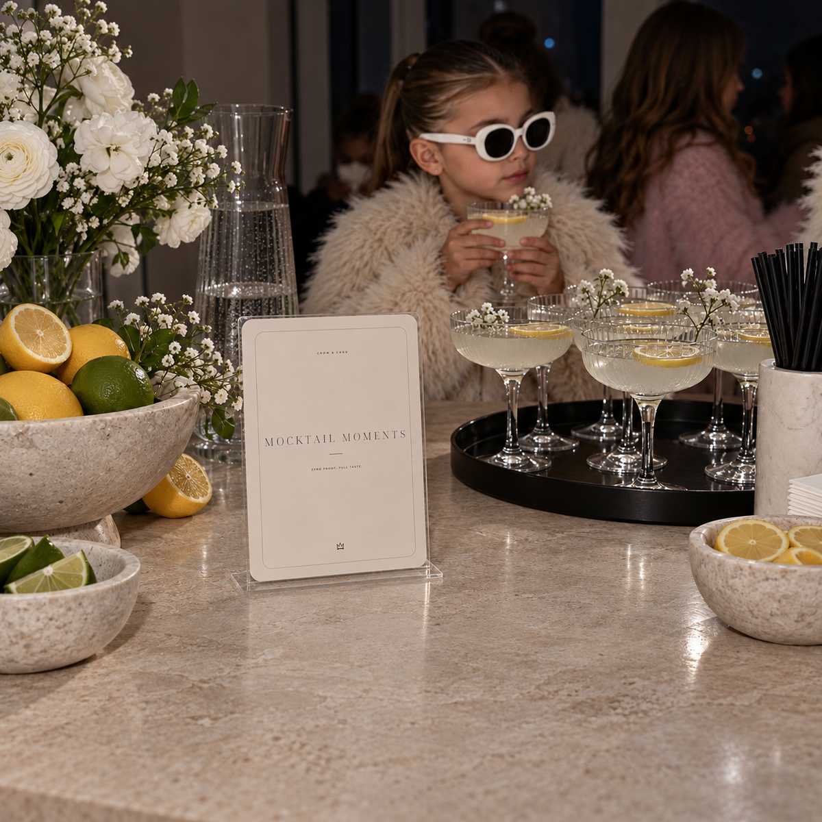 Mocktail Moments fashion birthday sign beside coupe glasses at an evening drink station
