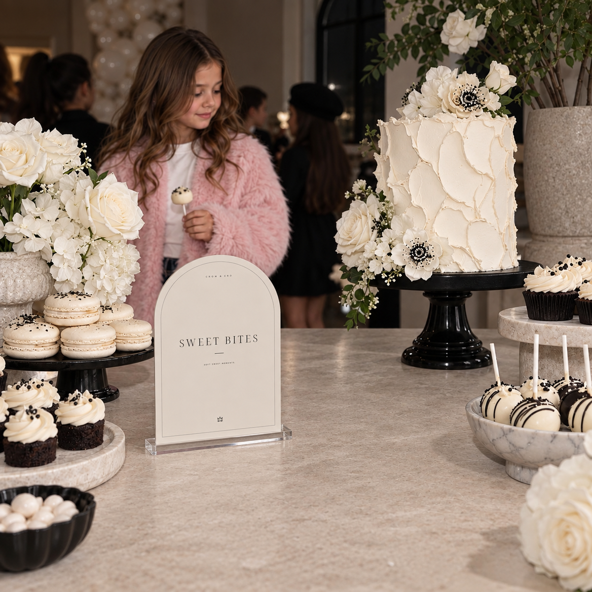 Sweet Bites fashion birthday sign beside a white cake and small desserts