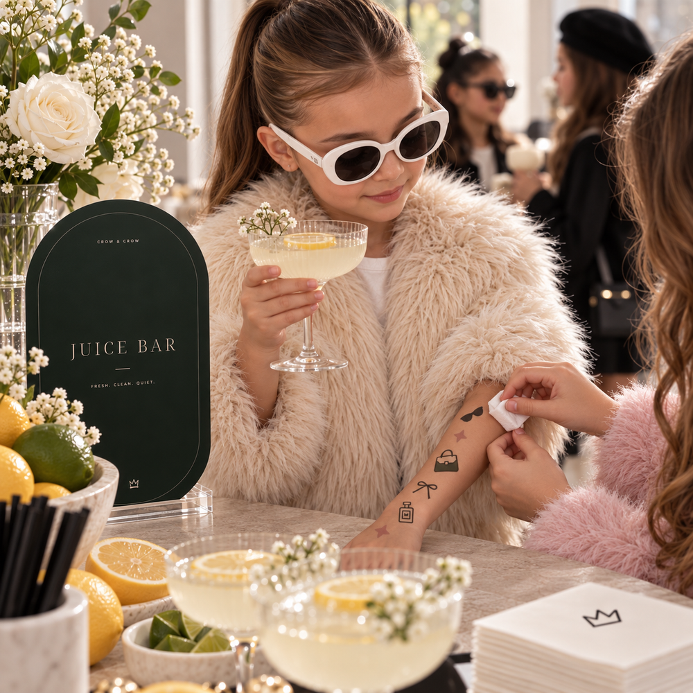Fashion temporary tattoos being applied to a child’s forearm beside a birthday drink station