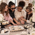 Four children displaying and applying fashion temporary tattoos at a party table