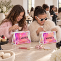 Close view of Harper and Sophia personalized holographic makeup pouches at a party table