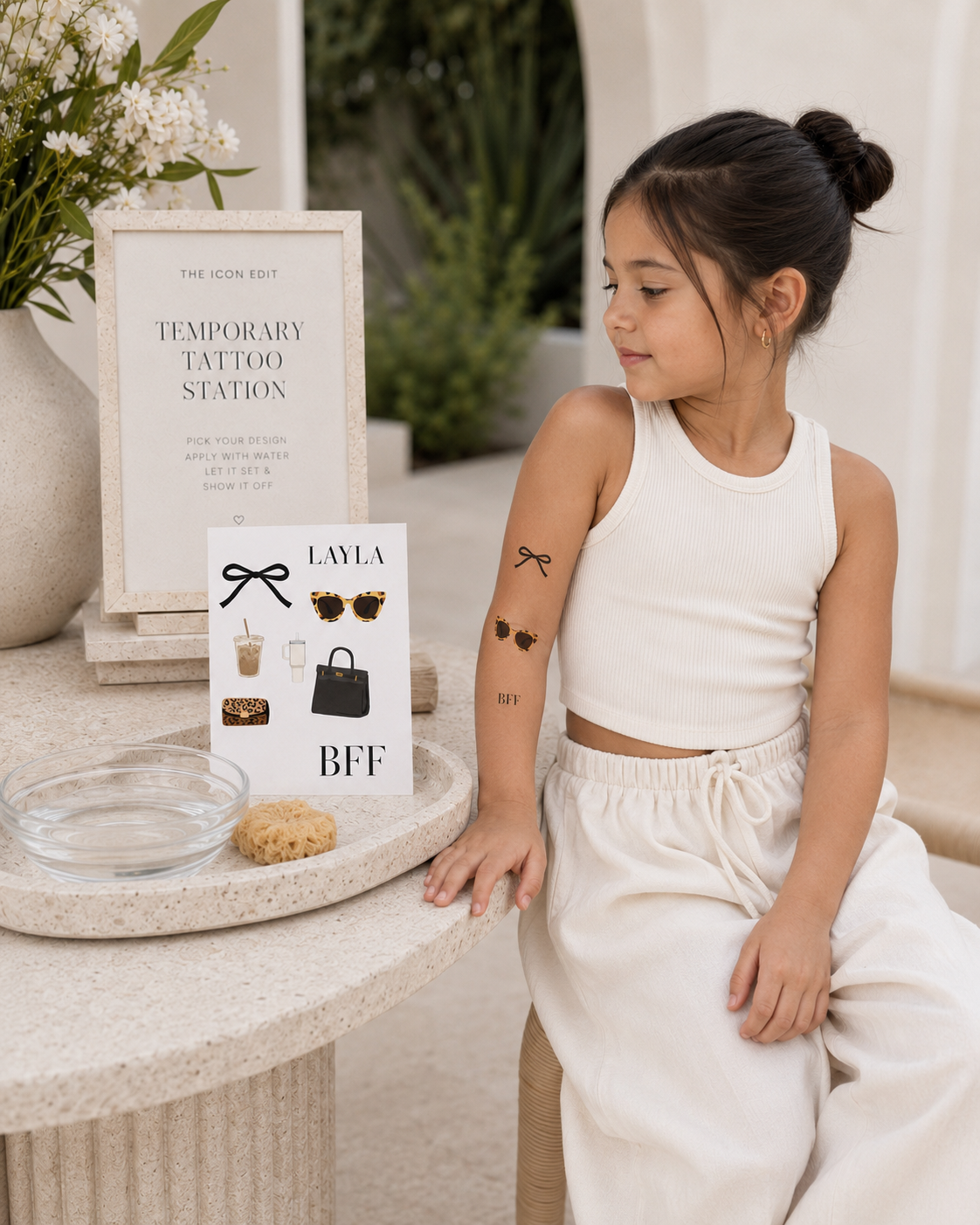 Girl seated beside a personalized fashion temporary tattoo station
