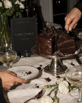 Cake Table printable sign beside a sliced chocolate cake and silver serving pieces