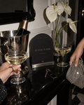The After Dark Party arched printable sign beside champagne bottles, coupe glasses and white flowers