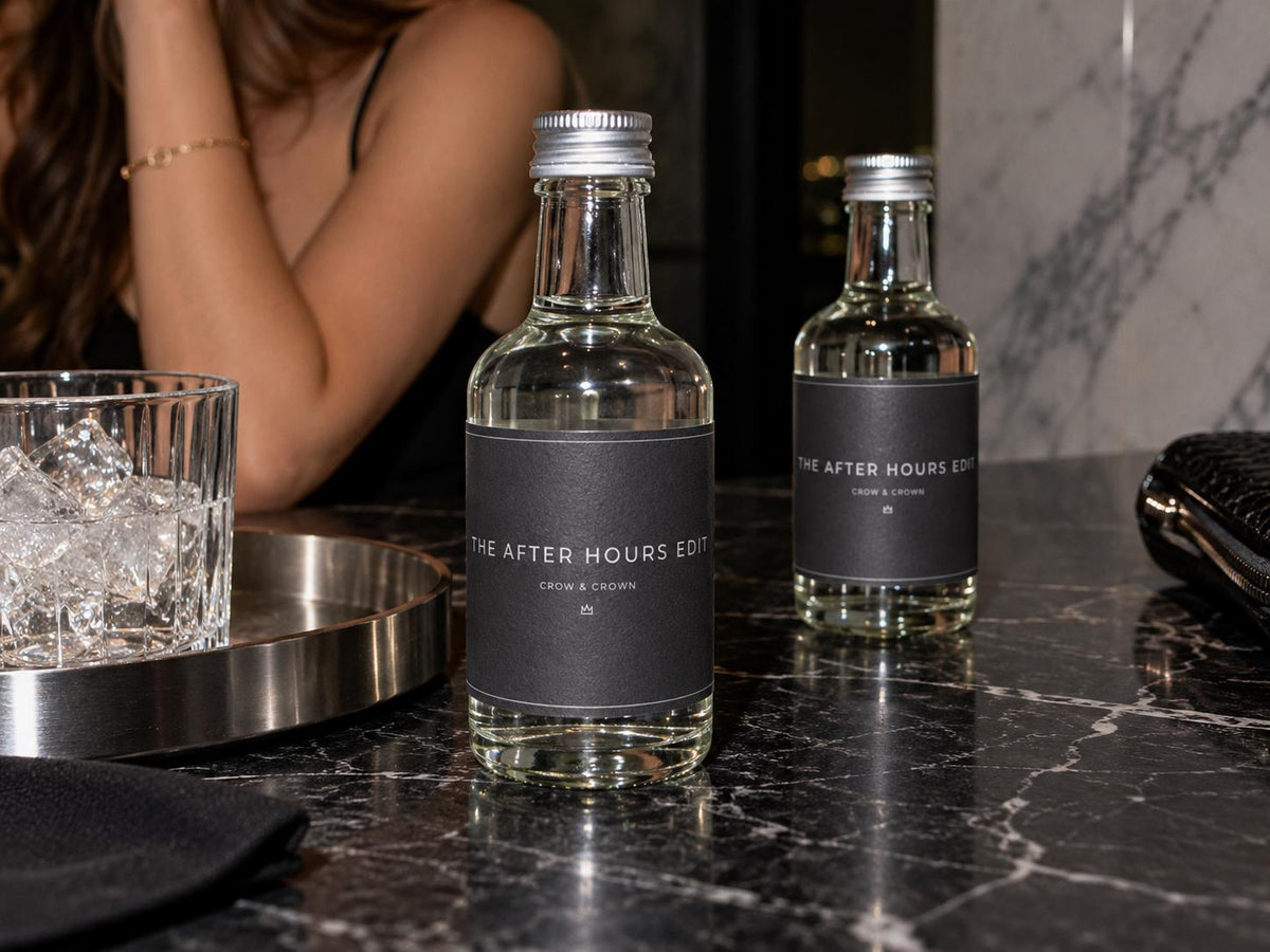 After Hours cocktail-party bottle wraps in dark gray and graphite beside glasses and an ice bucket