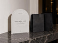 Until Next Time cocktail-party printable beside black favor bags on a console