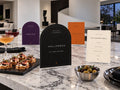 Halloween Edit station signs and ivory menu with food cards on a modern marble island