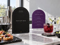 Near-black Potion Bar and purple Mocktail Menu Halloween printables at a marble drinks counter