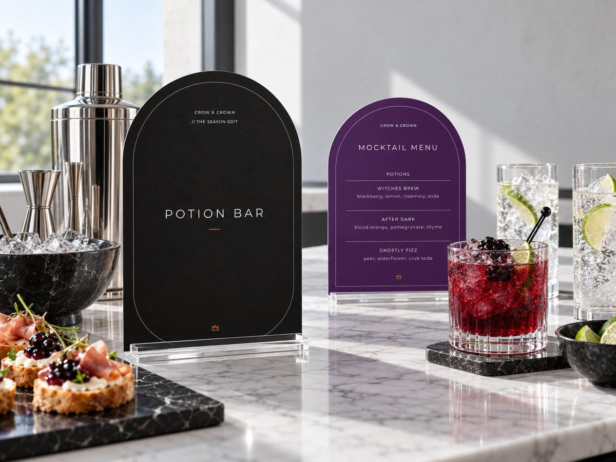 Near-black Potion Bar and purple Mocktail Menu Halloween printables at a marble drinks counter
