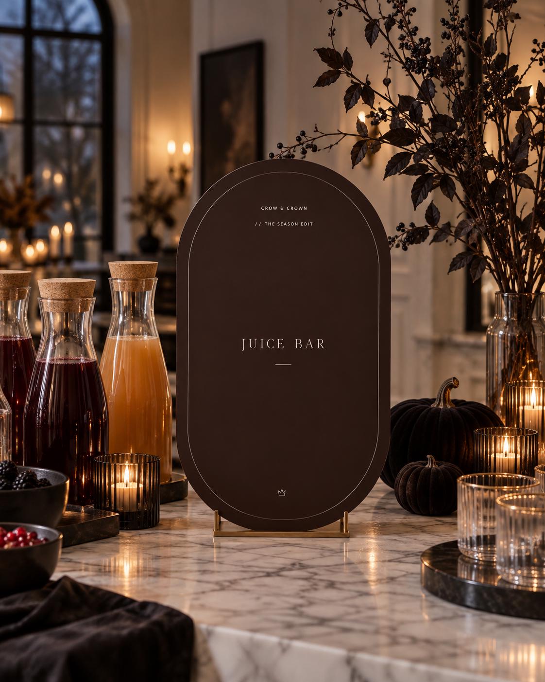 Juice Bar Halloween printable beside carafes, glassware and a black pumpkin