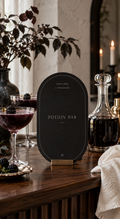 Potion Bar Halloween printable beside dark drinks and a glass decanter
