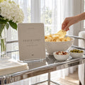 Snack Cart fashion birthday printable beside chips, nuts and olives on a serving trolley