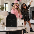 Strike a Pose fashion birthday printable beside an instant camera and children in party outfits