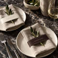 Espresso and ivory Thanksgiving napkin accents on linen with olive sprigs