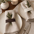 Thanksgiving napkin accent close-up on folded linen with olive sprigs and cutlery