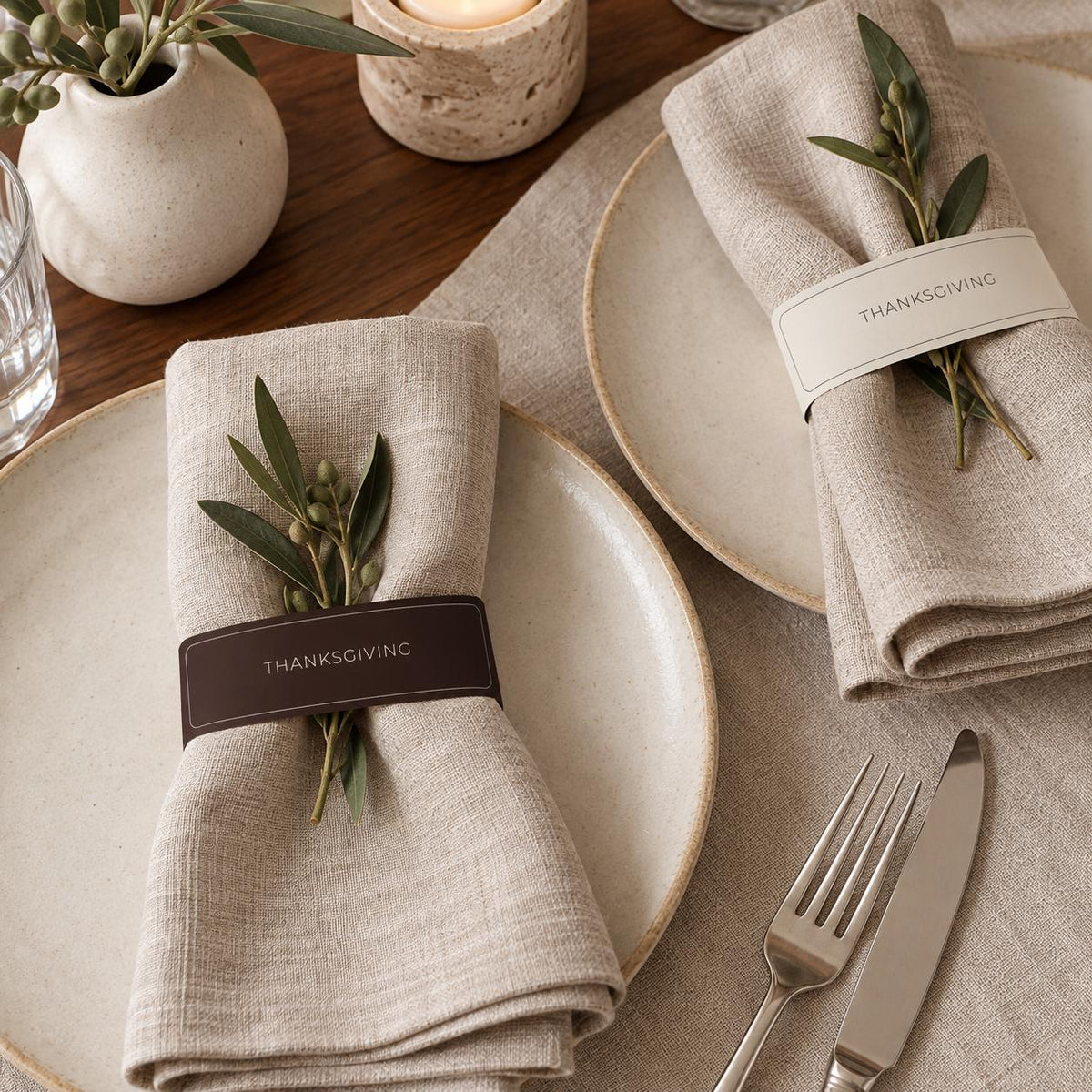 Thanksgiving napkin accent close-up on folded linen with olive sprigs and cutlery